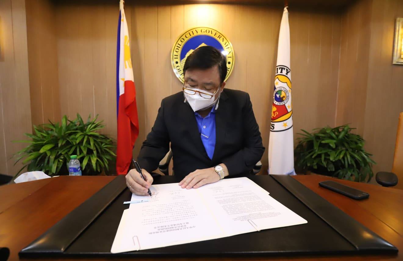 Mayor Jerry Trenas signing sister city deal with Quanzhou, China.