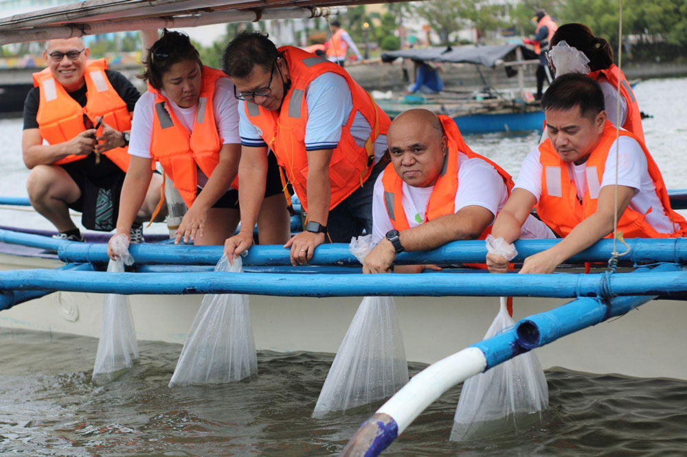 Executives of MORE Power Iloilo led the releasing of over 1000 fingerlings in Iloilo River.